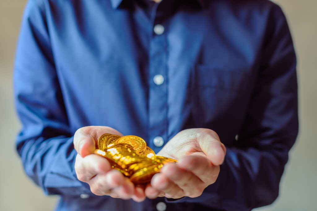 Hands holding gold coins