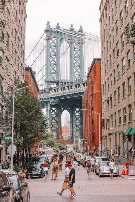 Manhattan Bridge framed by brick buildings on a Brooklyn street