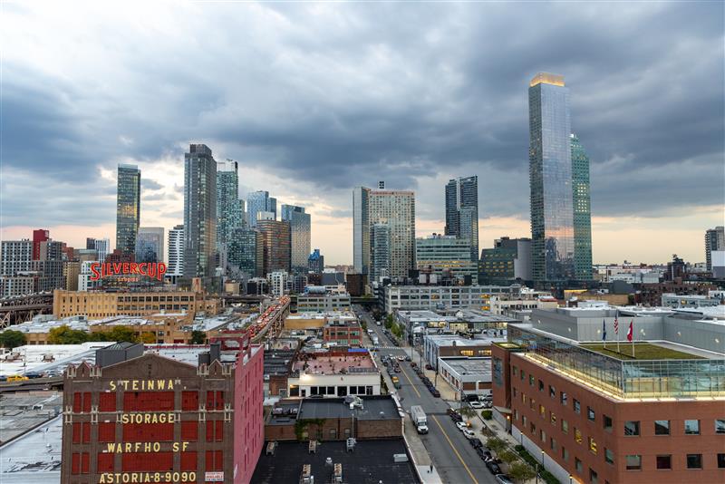City skyline of high-rise towers beneath a cloudy sky