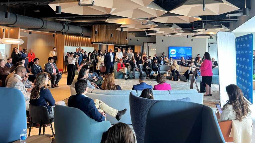 Group of people gathered in a large modern open-plan office space